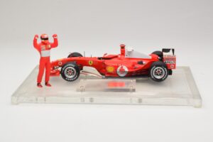 Ferrari F2004 #1 M. Schumacher F1 World Champion 2004 Z Dirkalnim Kombinezonom Hot Wheels 1:18 B66221 Kovina – slika 3 od 6