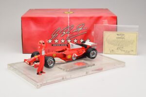 Ferrari F2004 #1 M. Schumacher F1 World Champion 2004 Z Dirkalnim Kombinezonom Hot Wheels 1:18 B66221 Kovina – slika 6 od 6